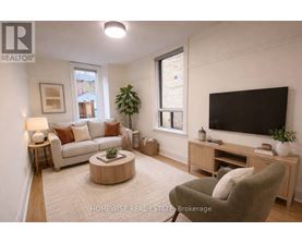 A living room with a couch, a coffee table, a television, and a plant.