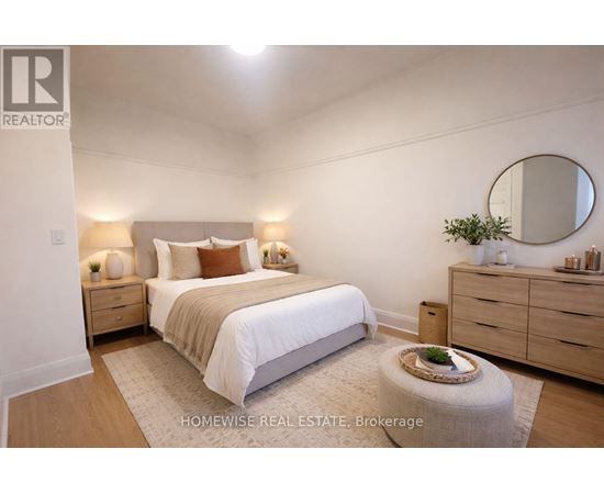 A bedroom with a bed, nightstands, and a round mirror on the wall.
