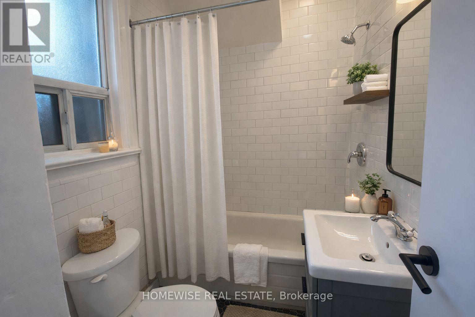 A bathroom with a toilet, sink, and shower.