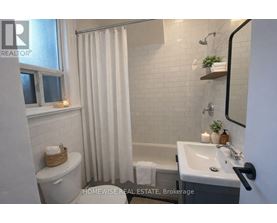 A bathroom with a toilet, sink, and shower.