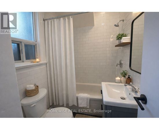 A bathroom with a toilet, sink, and shower.