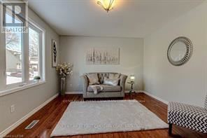 A living room with a grey couch and a white rug.