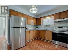 A kitchen with wooden cabinets and a stainless steel refrigerator.