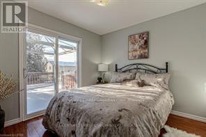 A bedroom with a bed, a lamp, and a painting on the wall.