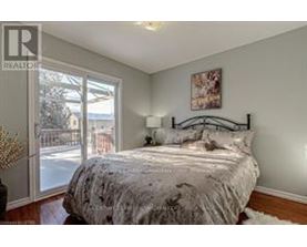 A bedroom with a bed, a lamp, and a painting on the wall.