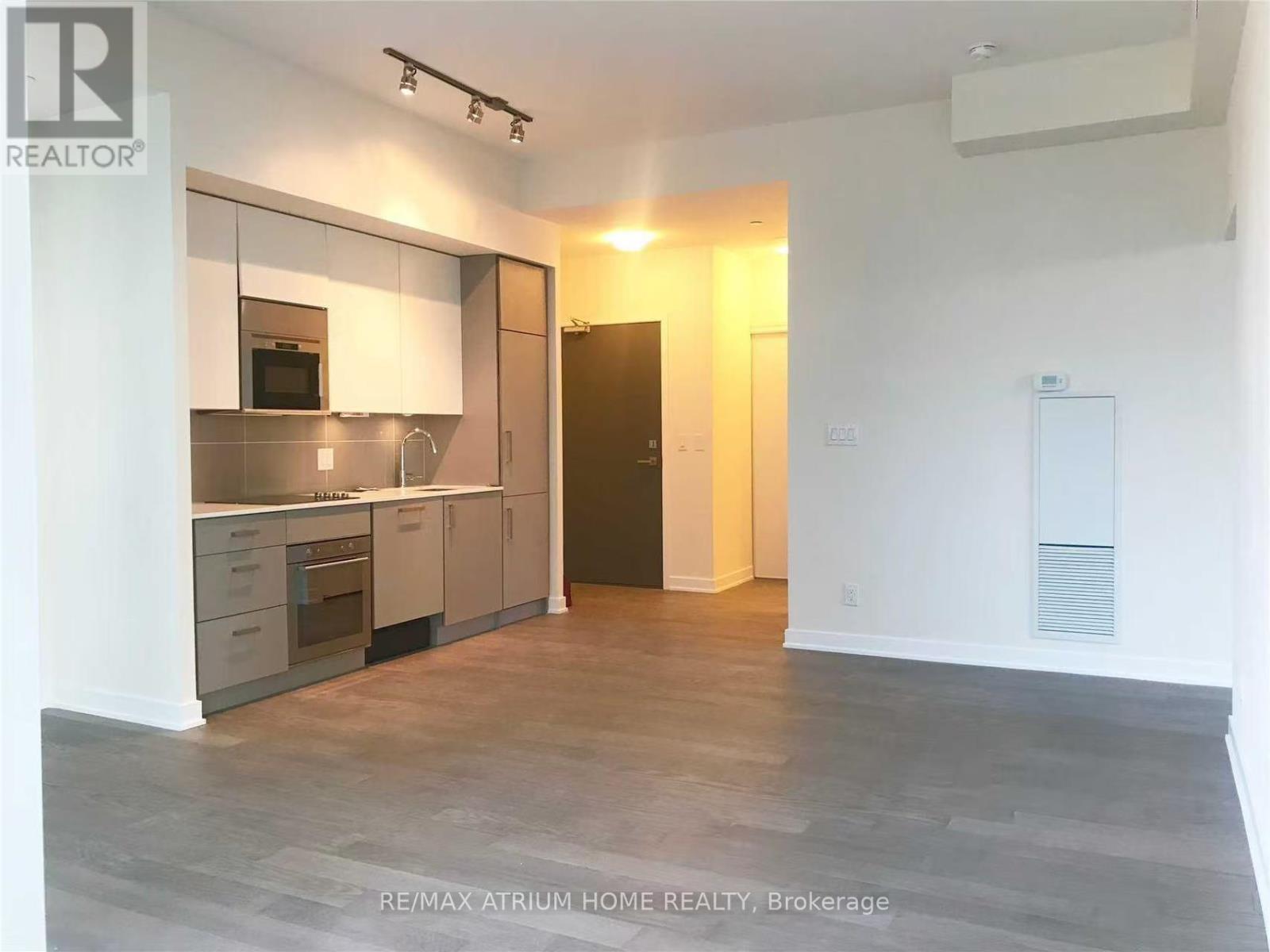 A spacious kitchen with a refrigerator, oven, and microwave.