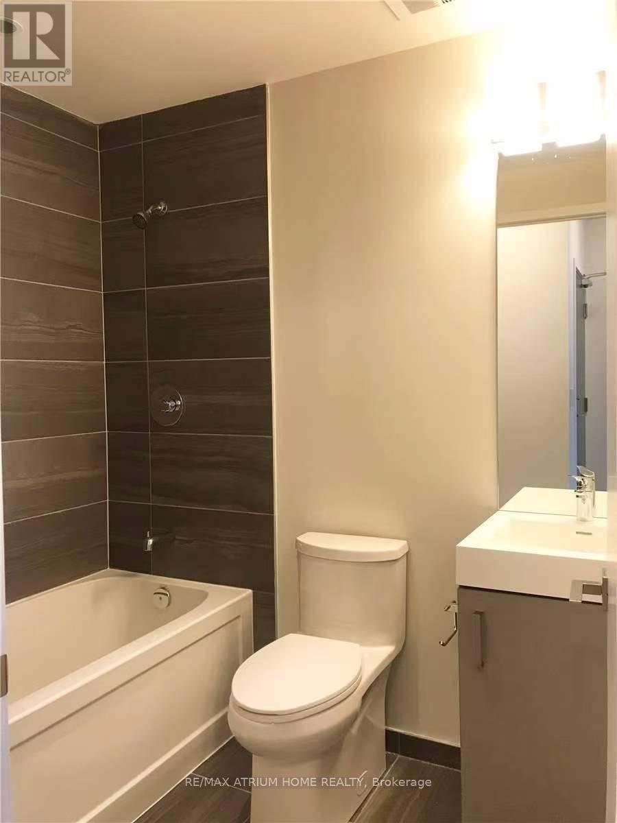 A white toilet sits next to a white sink in a bathroom.