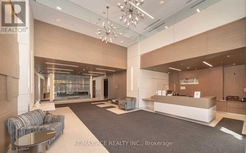 A spacious office lobby with a reception desk and a seating area.