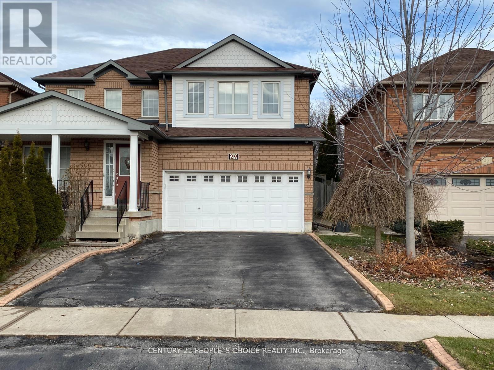 A house with a garage and a driveway in front of it.