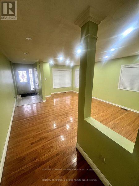 A long hallway with wood floors and green walls.