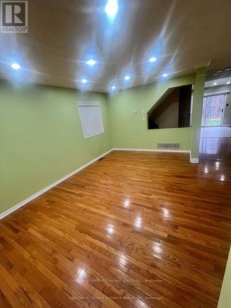 A room with wooden flooring and a green wall.
