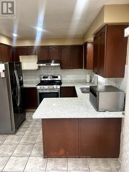 A kitchen with brown cabinets and a granite counter.