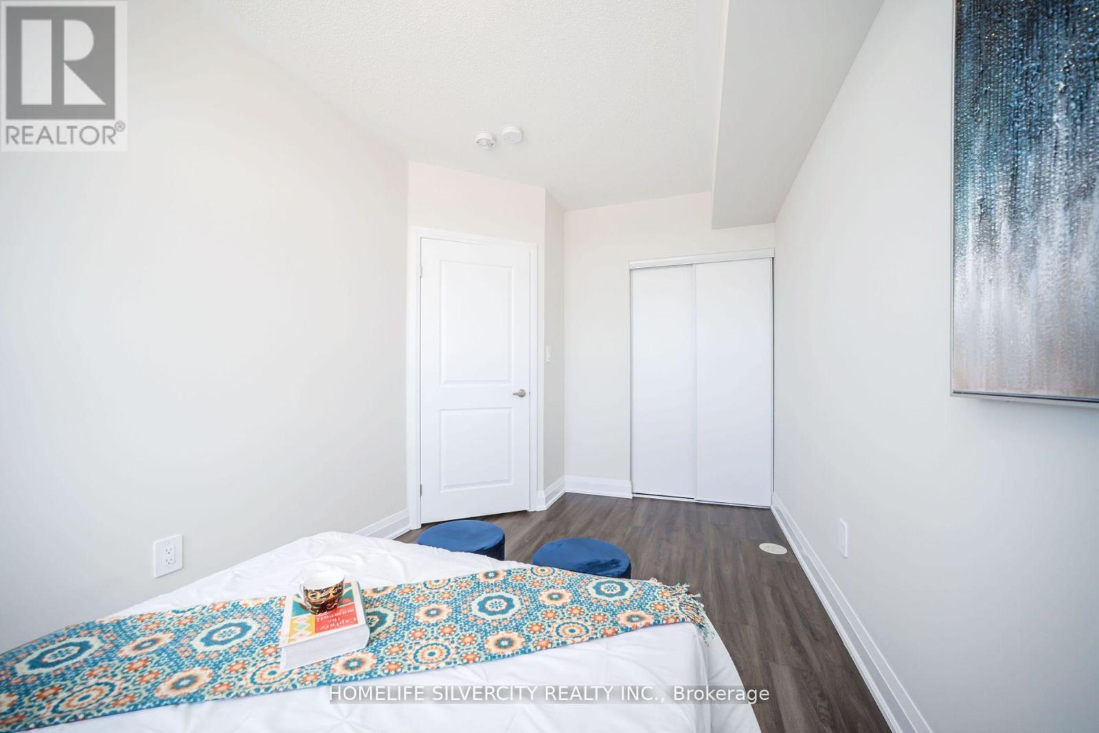 A bedroom with a bed and a painting on the wall.