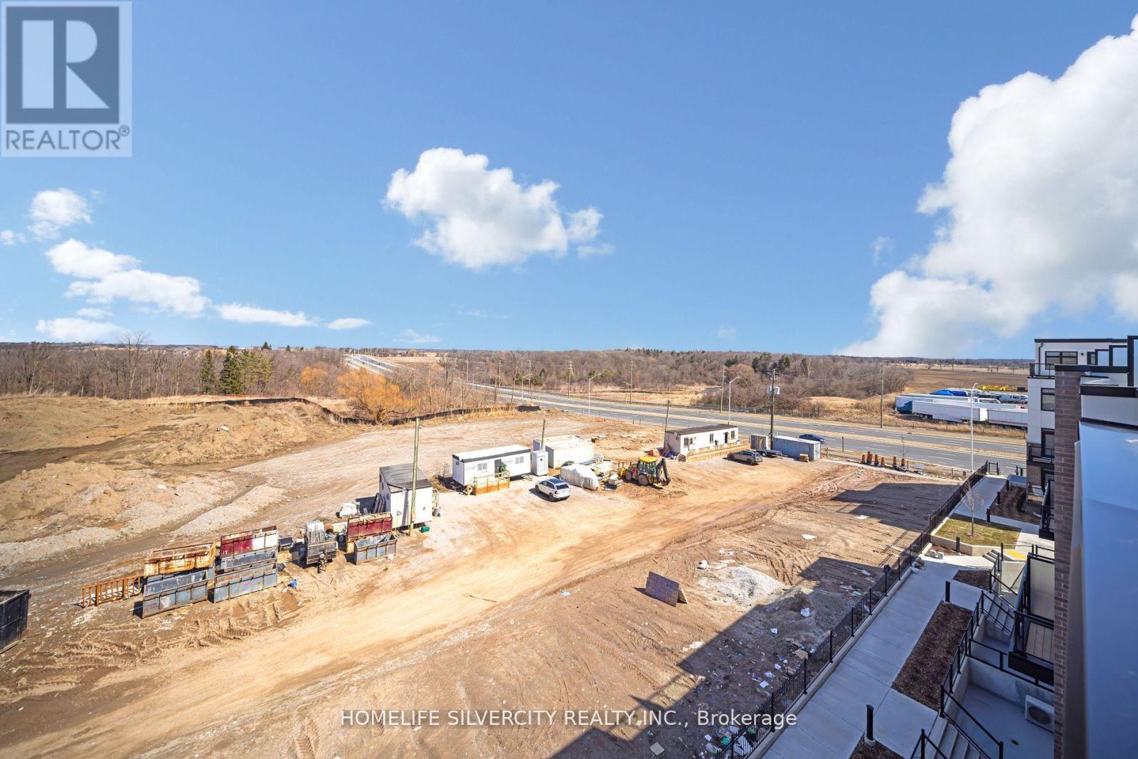 A construction site with a building and a truck in the foreground.