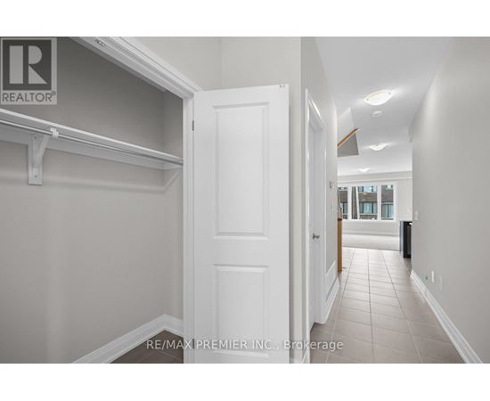 A hallway with a white door and a brokerage sign on the wall.