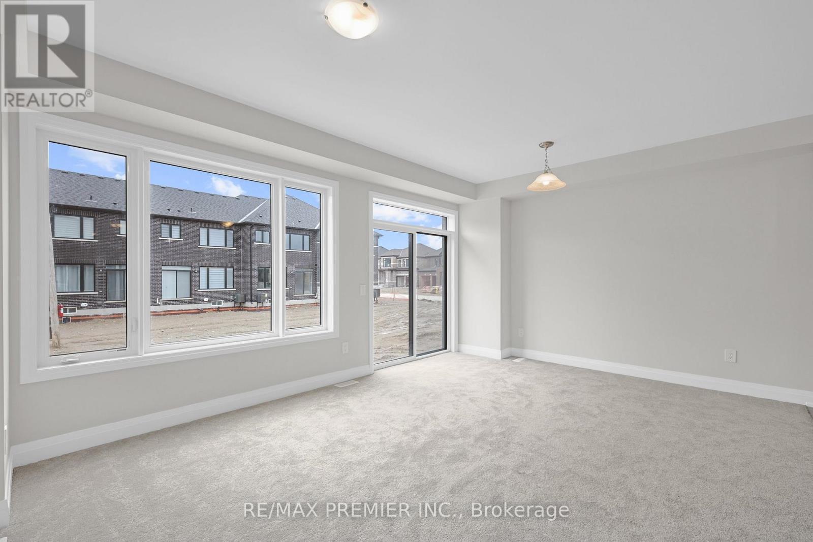 A spacious room with a large window and a sliding glass door.
