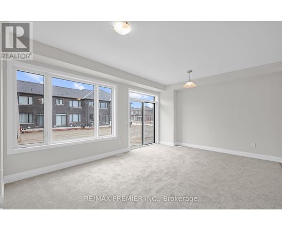 A spacious room with a large window and a sliding glass door.