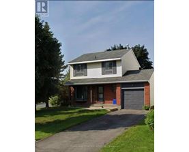 A house with a grey roof and a brick chimney is for sale.