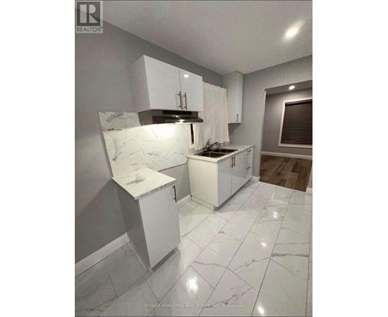 A kitchen with white cabinets and marble countertops.