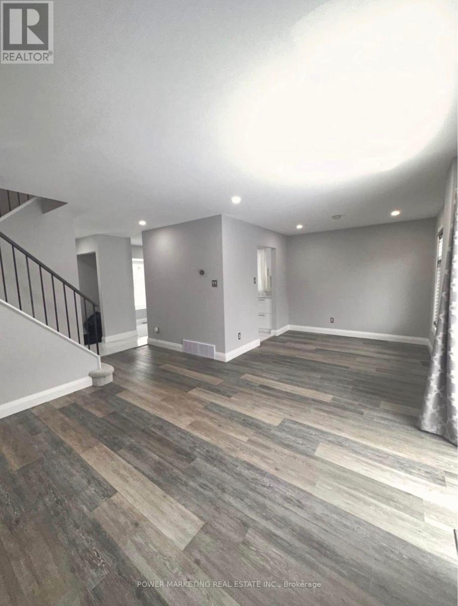 A room with wooden flooring and a staircase.