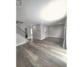 A room with wooden flooring and a staircase.