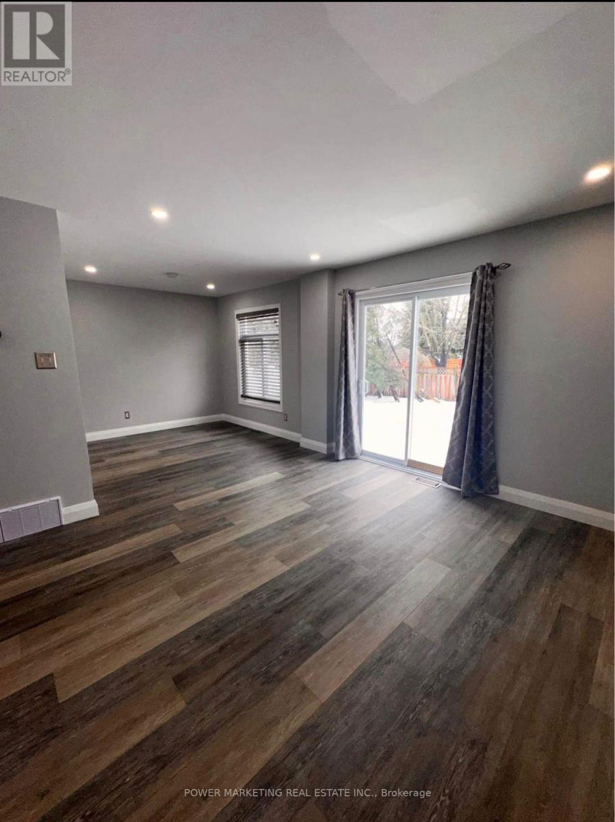 A room with wooden flooring and a sliding glass door.