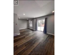 A room with wooden flooring and a sliding glass door.