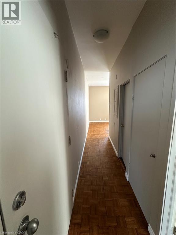 A long hallway with wood floors and white walls.