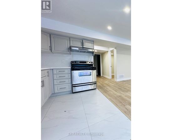 A modern kitchen with a stainless steel oven and wooden flooring.