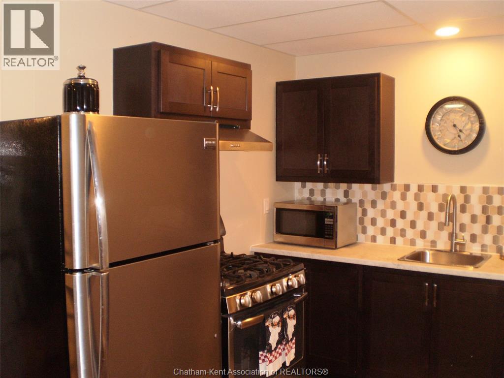 A kitchen with a refrigerator, microwave, and oven.