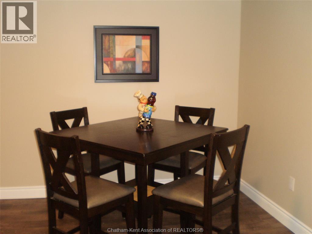 A dining room with a wooden table and chairs.