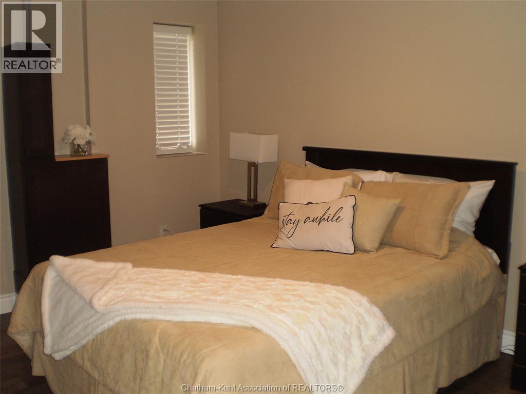 A bedroom with a bed, nightstand, and lamp.