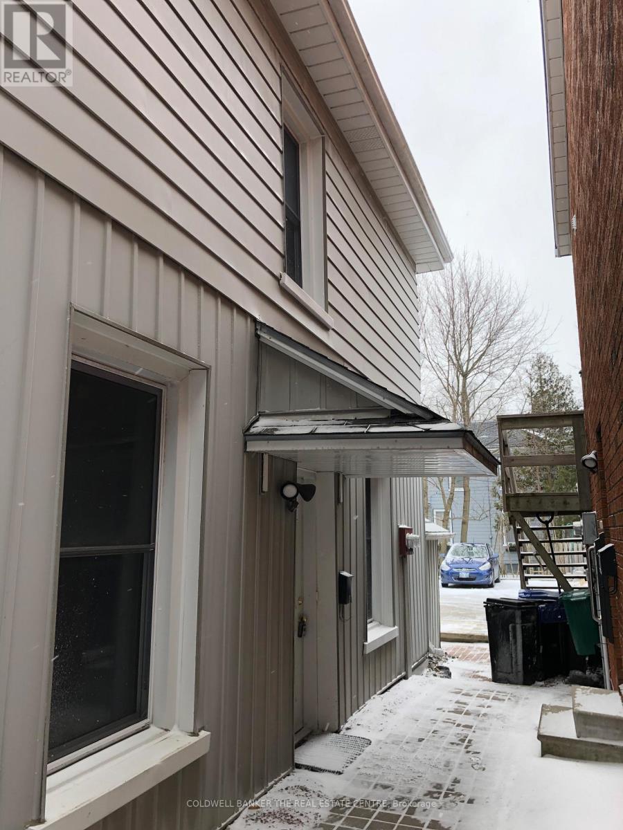 A house with a white siding and a covered walkway.
