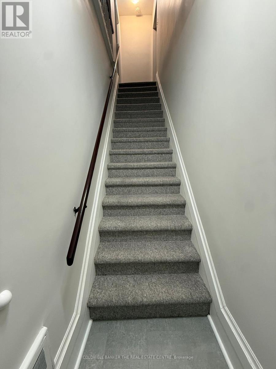 A staircase with a carpeted runner and a wooden handrail.