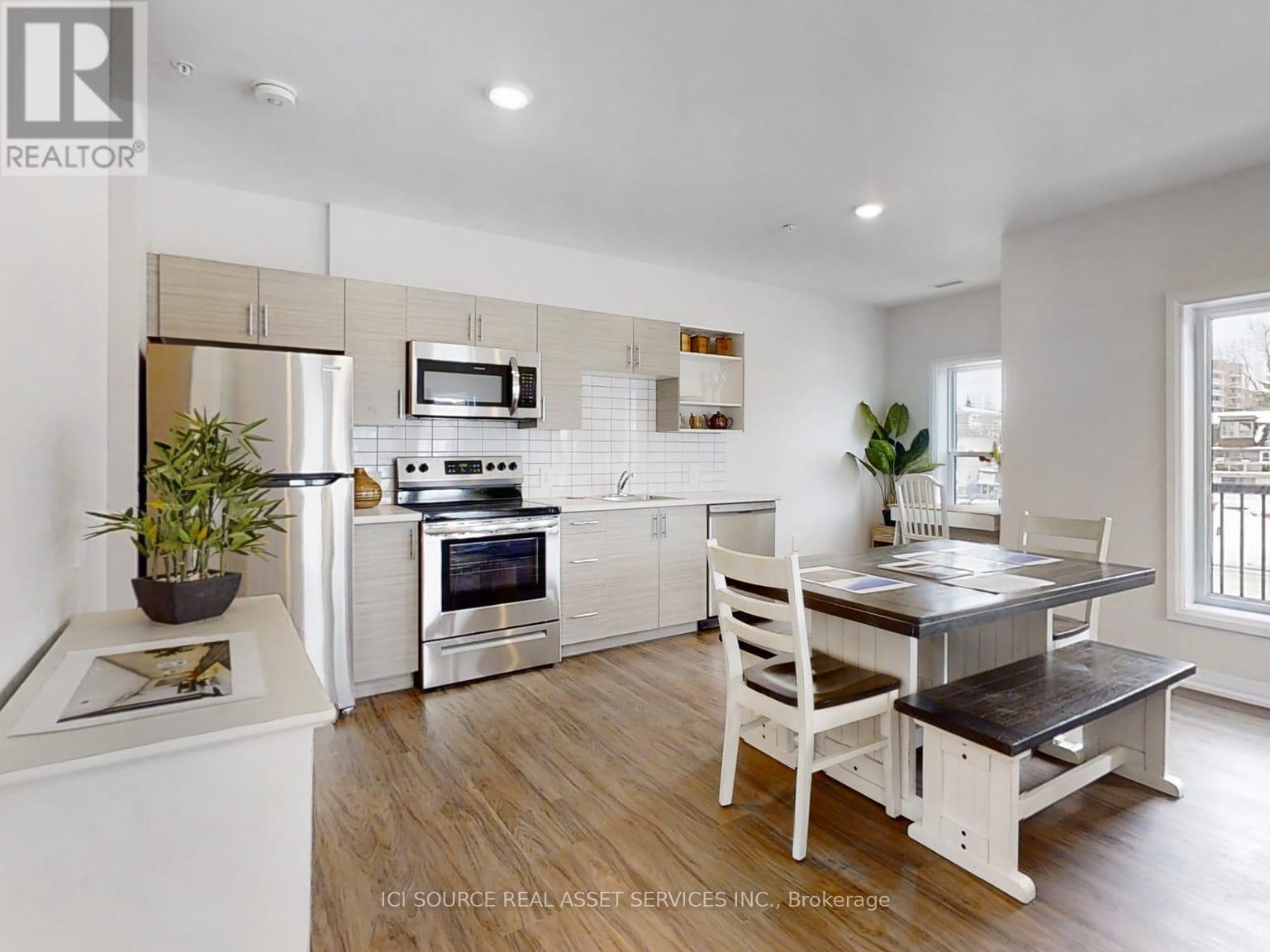A modern kitchen with white cabinets and a wooden table.