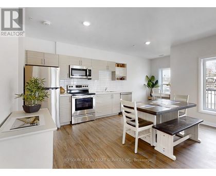 A modern kitchen with white cabinets and a wooden table.