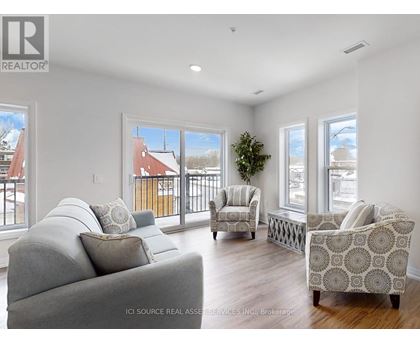 A living room with a grey couch and a patterned armchair.