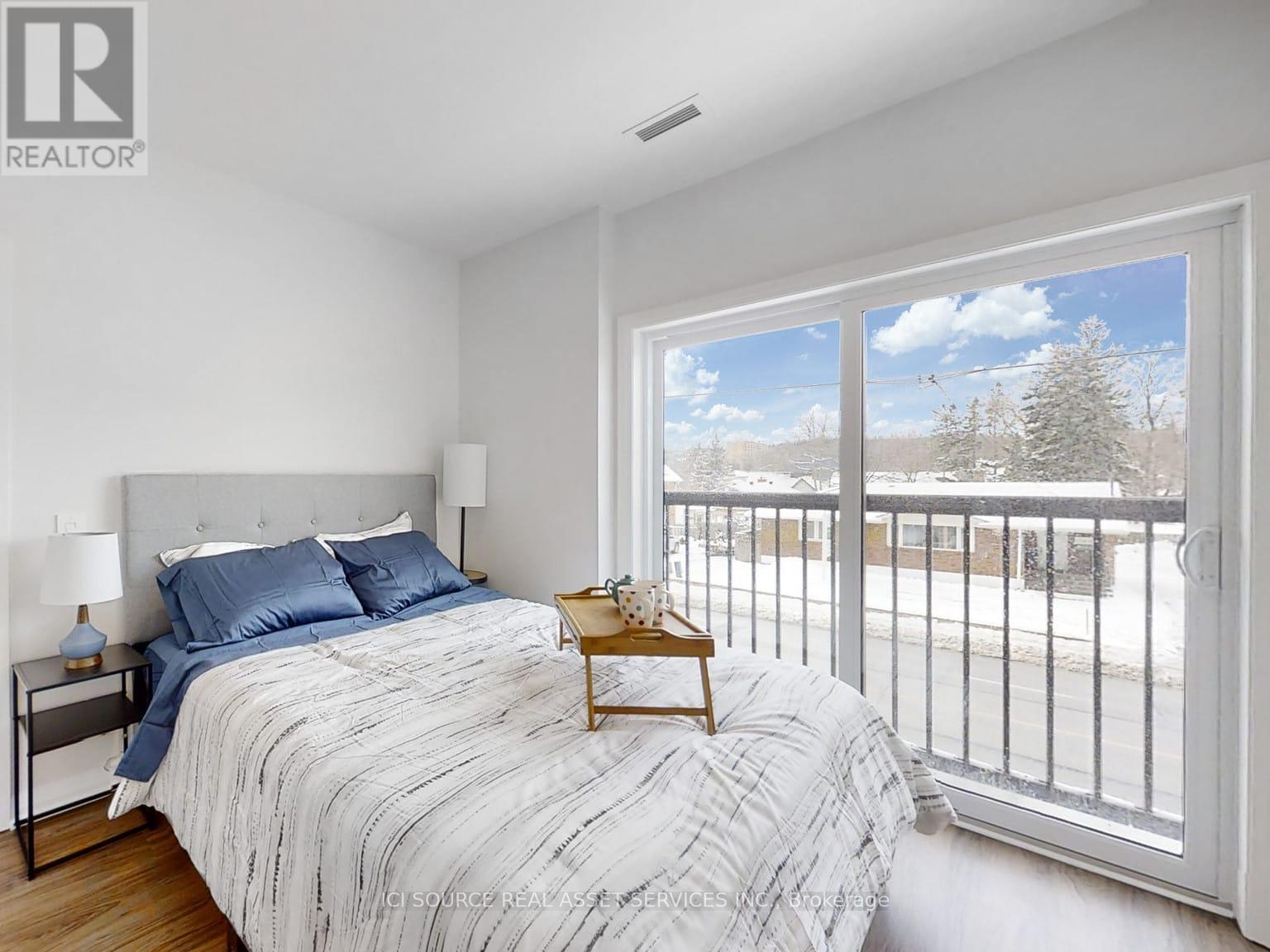A bedroom with a large bed and a view of the outside.