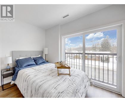 A bedroom with a large bed and a view of the outside.