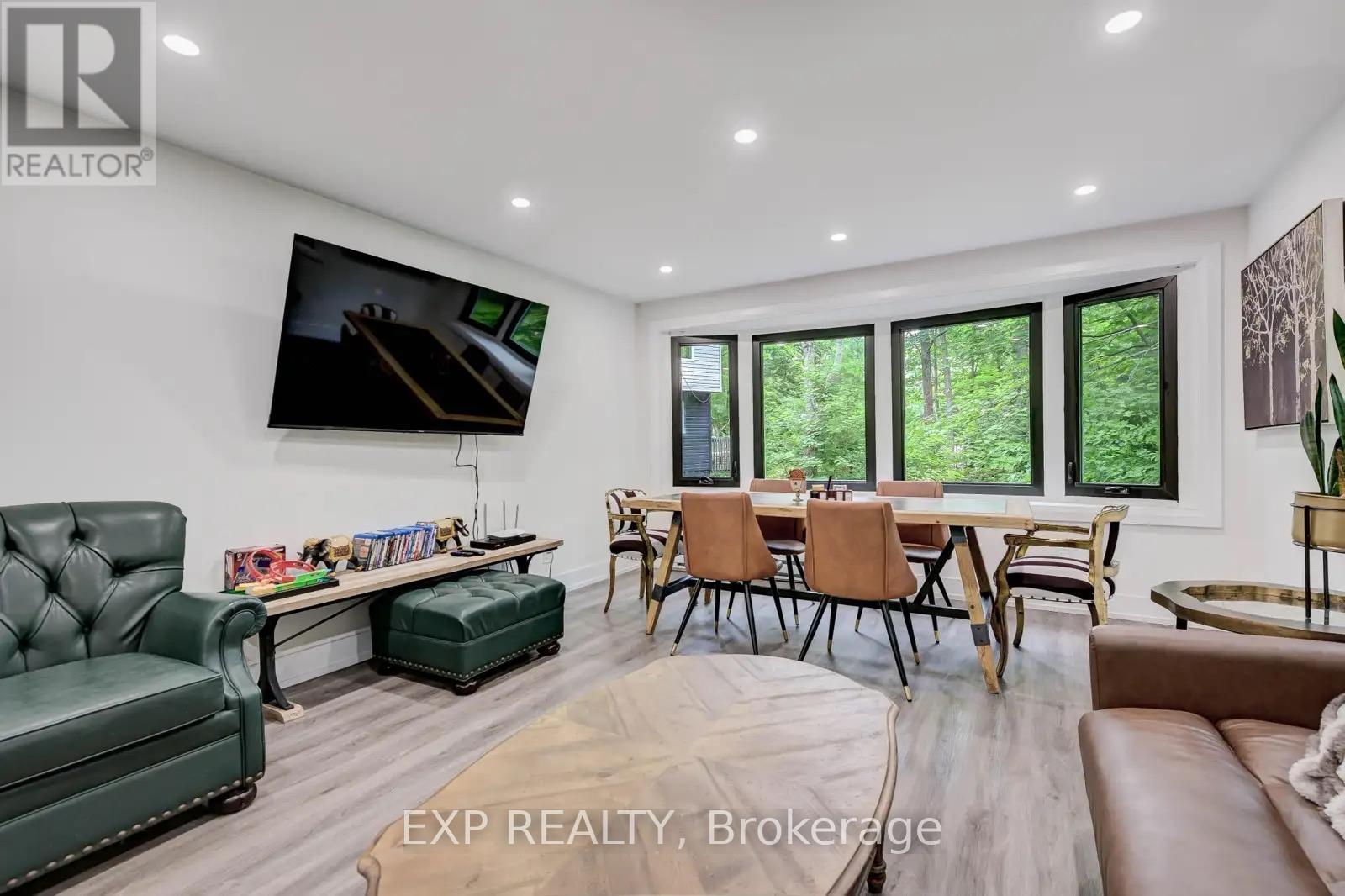 A living room with a green couch, a television, and a dining table with chairs.