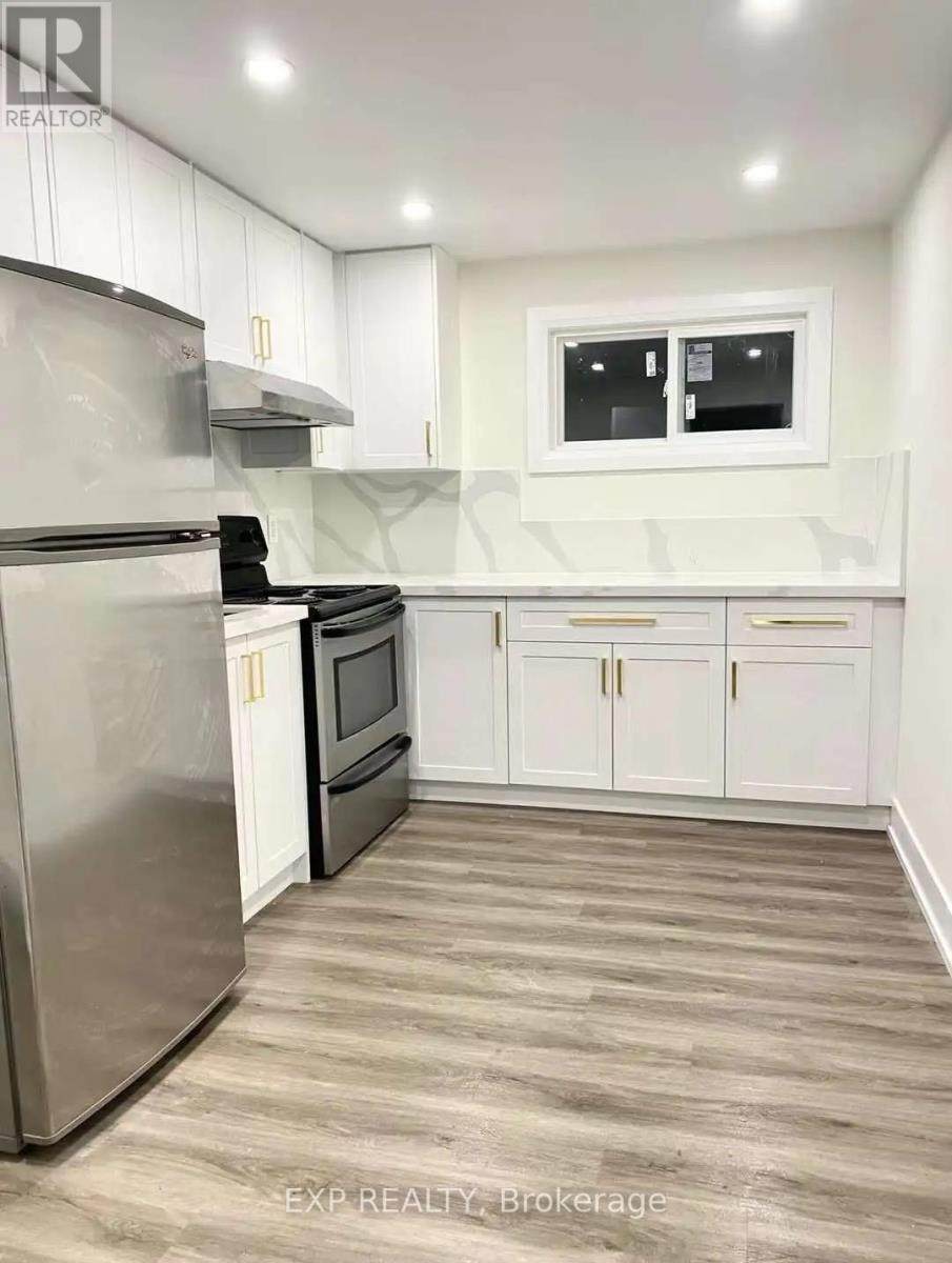 A kitchen with white cabinets and a stainless steel refrigerator.