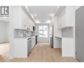 A modern kitchen with white cabinets and stainless steel appliances.