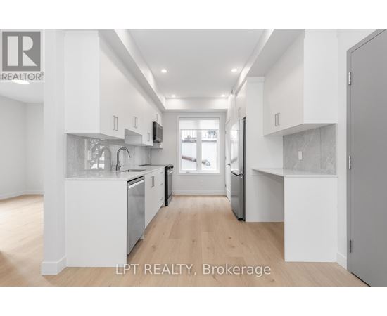 A modern kitchen with white cabinets and stainless steel appliances.