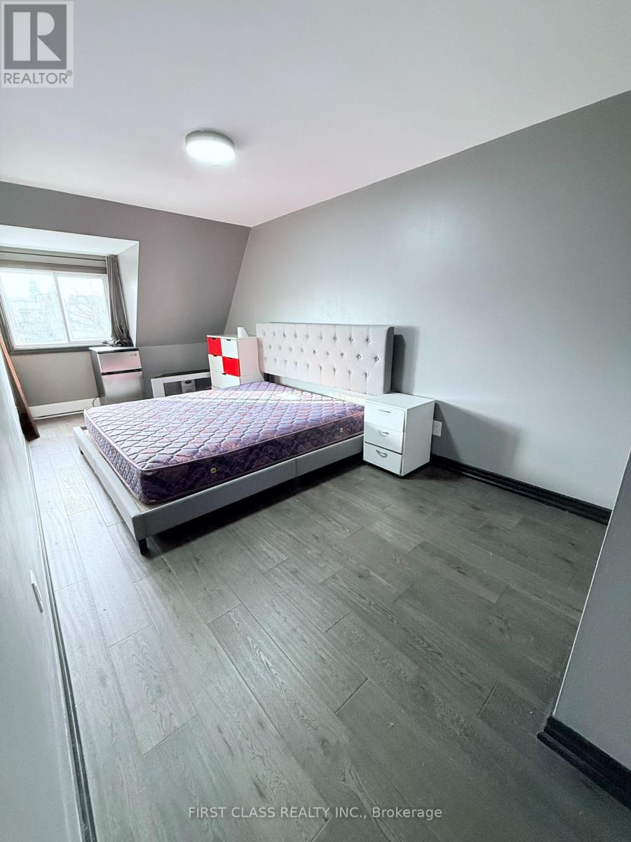 A bedroom with a bed, nightstand, and chair.