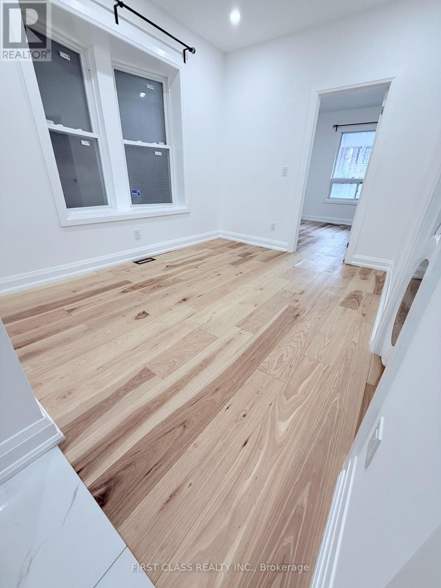 A room with wooden flooring and white walls.