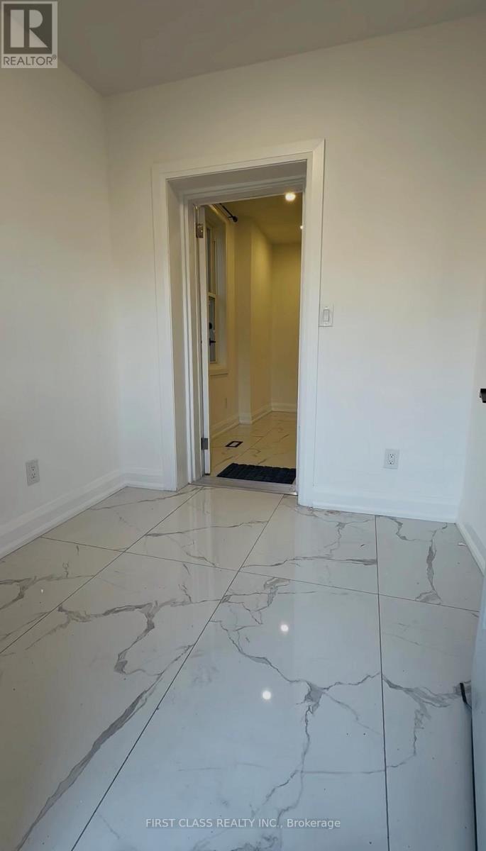 A hallway with marble flooring and a doorway leading to another room.
