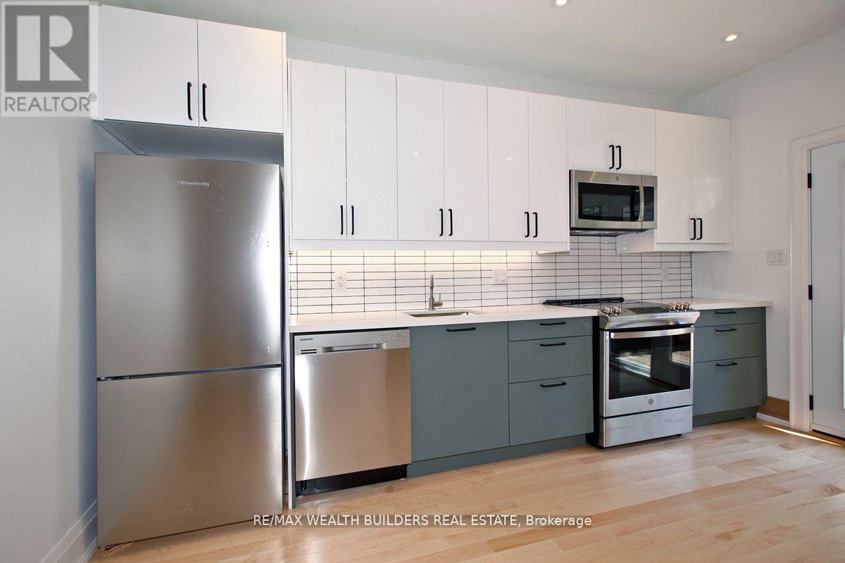 A kitchen with a refrigerator, microwave, dishwasher, and oven.