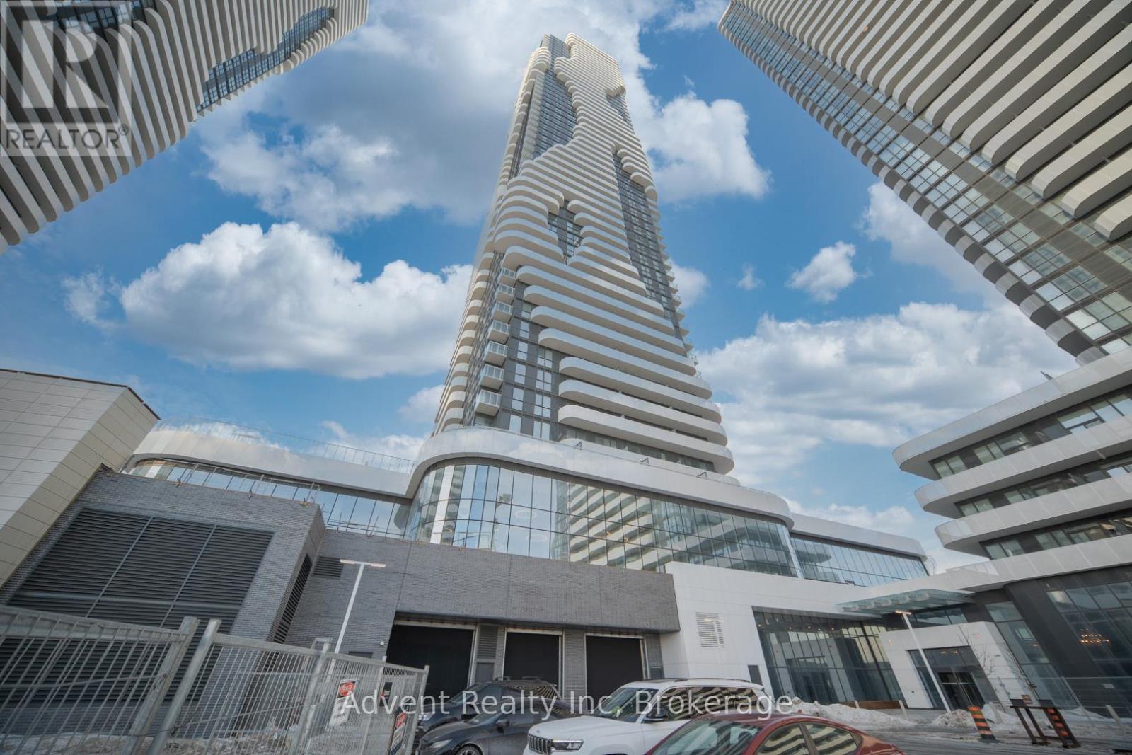 A tall building with a unique design stands out among other buildings.