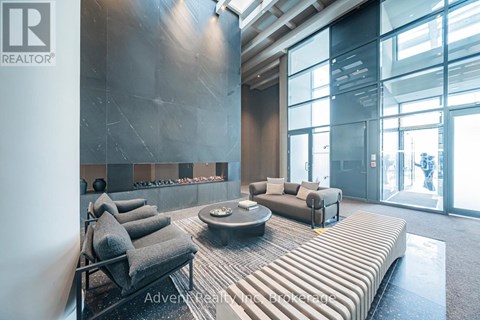 A modern living room with grey couches and a glass wall.
