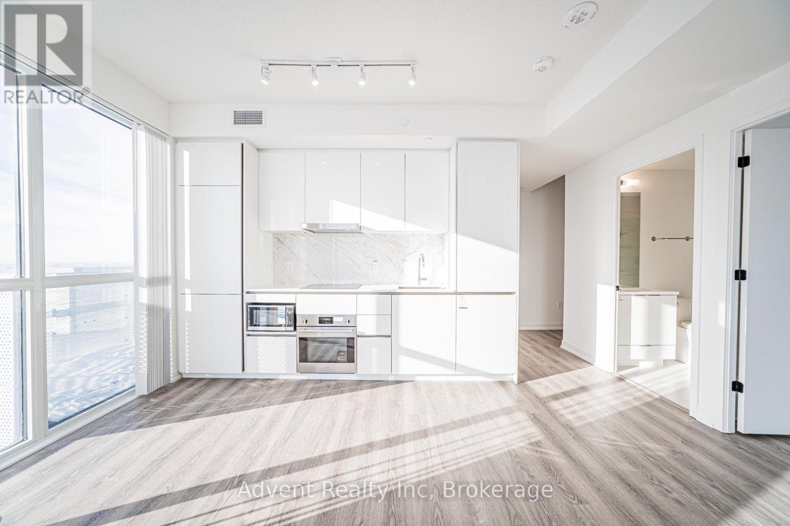 A modern kitchen with white cabinets and appliances.